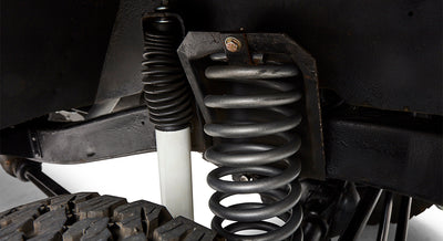 Close-up of black coil spring suspension and white shock absorber on Classic Ford Bronco