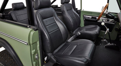 Interior view of Classic Ford Bronco showing black leather seats, dashboard, and steering wheel