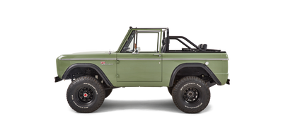 Side profile of green Classic Ford Bronco without a roof showing wheels and suspension