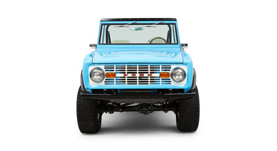 Front view of Classic Ford Bronco in blue with round headlights and white grille showing red FORD letters