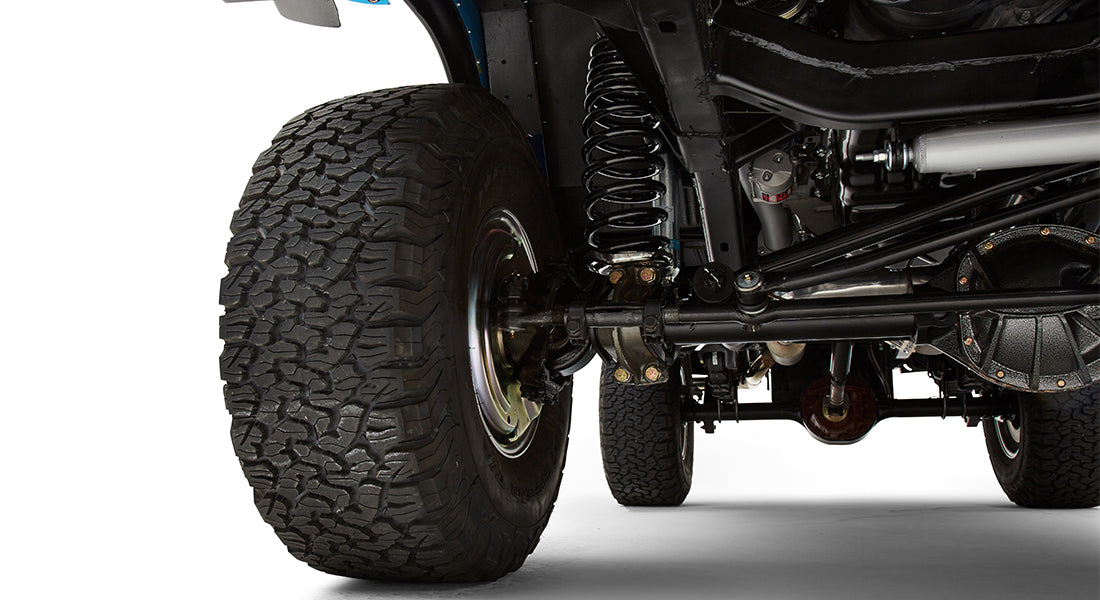 Close-up view of rear suspension and tires of classic Ford Bronco with coil springs and shock absorbers