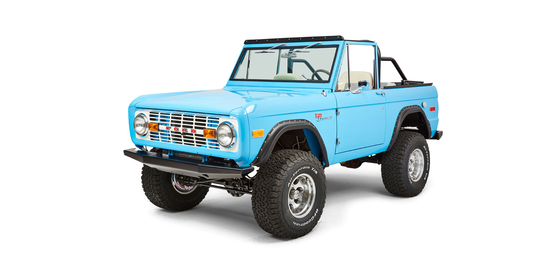 Another front three-quarter view of a bright blue Classic Ford Bronco angled from opposite side with white interior.