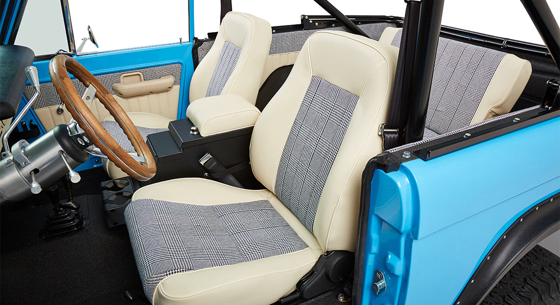 Front seats and interior door panel inside Classic Ford Bronco with beige and checked fabric