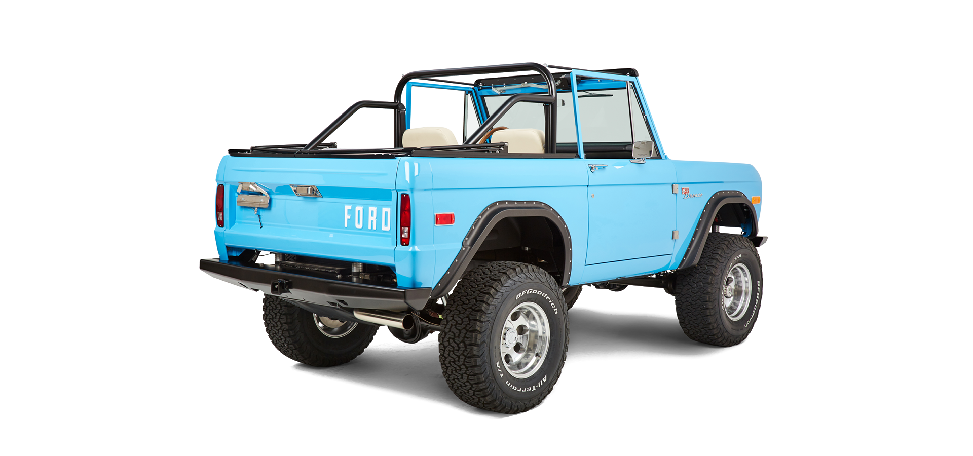 Rear three-quarter view of bright blue Classic Ford Bronco showing bed and roll cage.