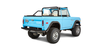 Rear three-quarter view of bright blue Classic Ford Bronco showing bed and roll cage.