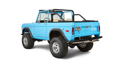 Classic Ford Bronco in blue shown from rear three-quarter side with off-road tires and roll cage