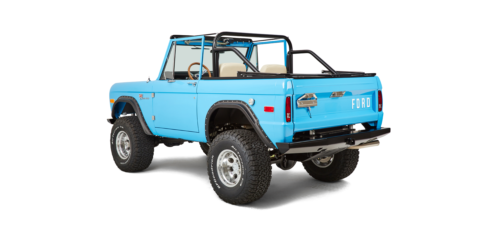 Rear three-quarter view of bright blue Classic Ford Bronco with Ford logo on tailgate.