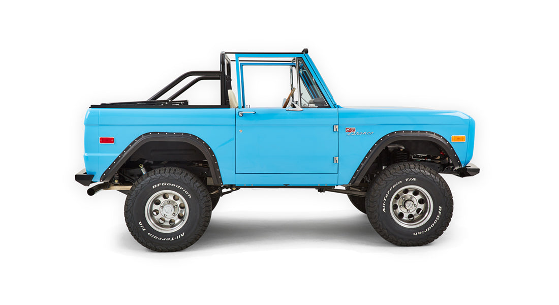 Side profile of Classic Ford Bronco in blue with large off-road tires and black fender flares