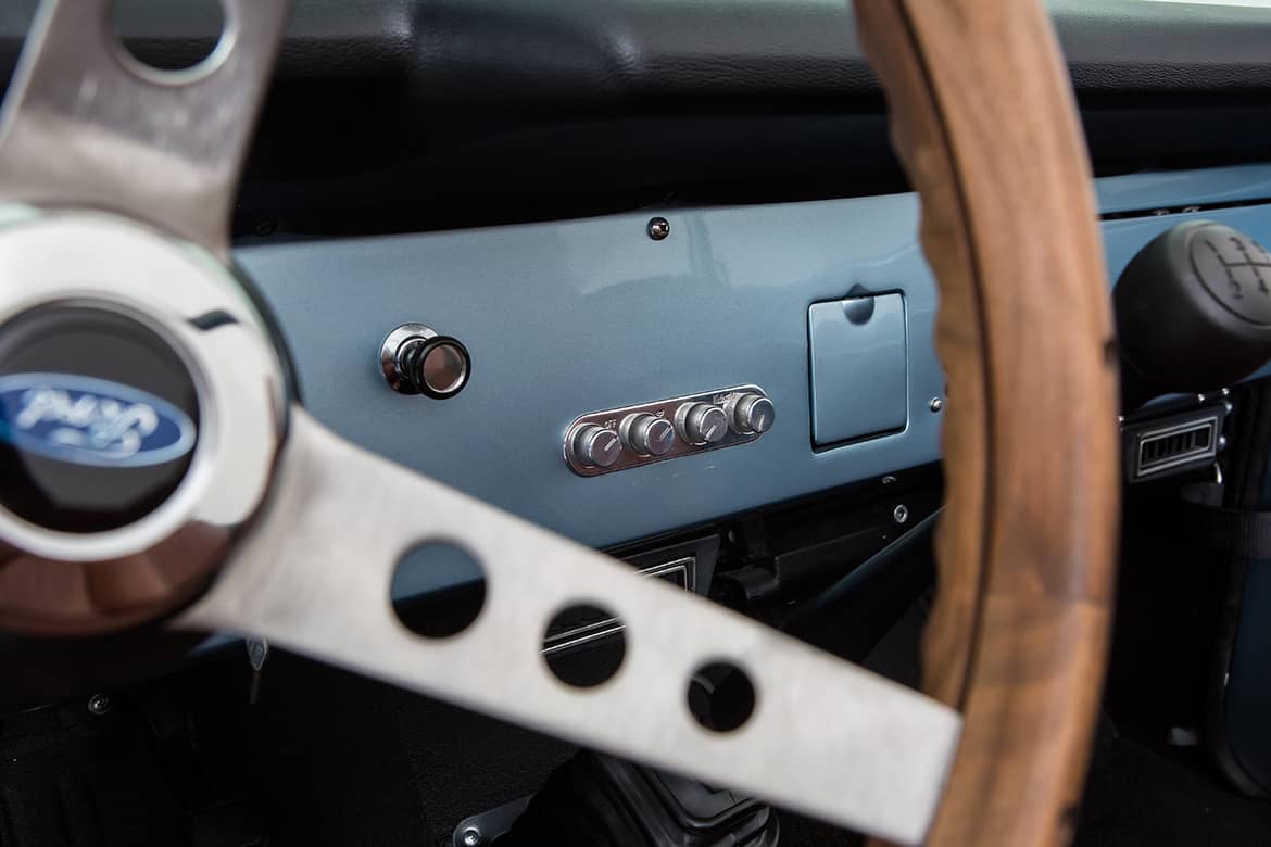 Interior dashboard of Classic Ford Bronco showing steering wheel and control knobs
