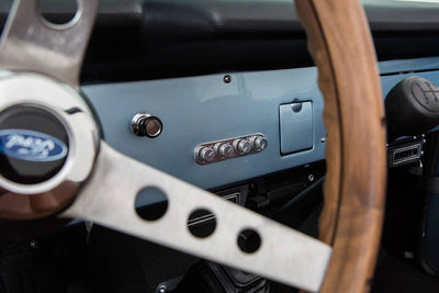 Interior dashboard of Classic Ford Bronco showing steering wheel and control knobs