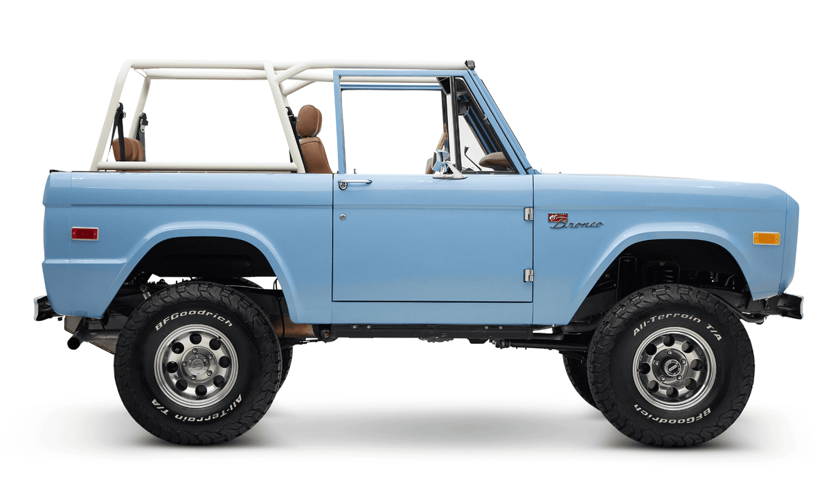 Classic Ford Bronco in frozen blue with tan interior and white roll cage side view