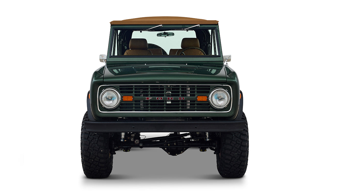 Front view of Classic Ford Bronco in dark forest green showing grille and headlights on white background