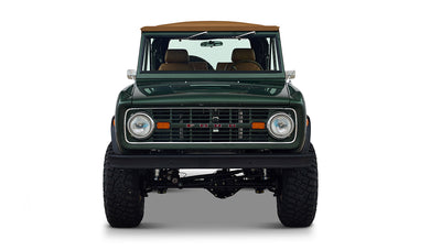 Front view of Classic Ford Bronco in dark forest green showing grille and headlights on white background