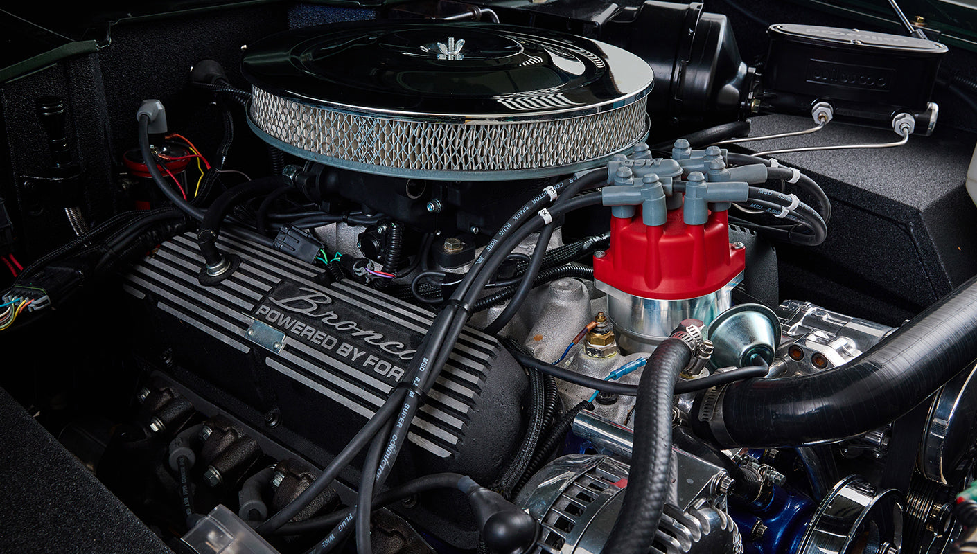 Engine block with red distributor cap and 'Bronco Powered by Ford' valve cover in Classic Ford Bronco
