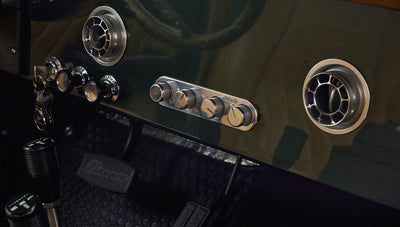 Close-up of gear shifters and surrounding black rubber floor mat inside Classic Ford Bronco interior