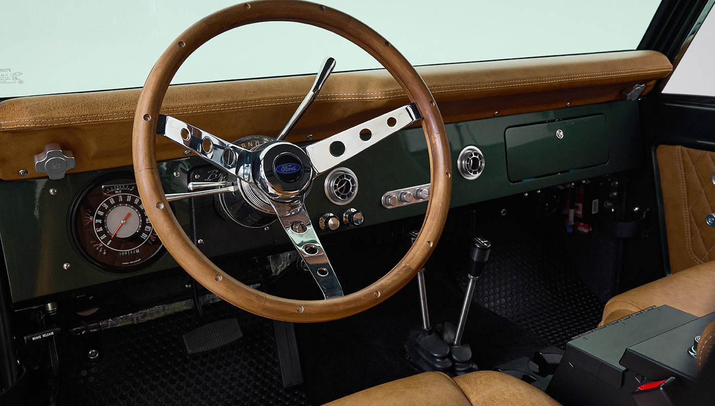 Dashboard controls and air vents with chrome finish inside dark green Classic Ford Bronco