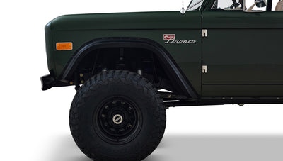 Side profile of Classic Ford Bronco showing front wheel and dark green front fender.