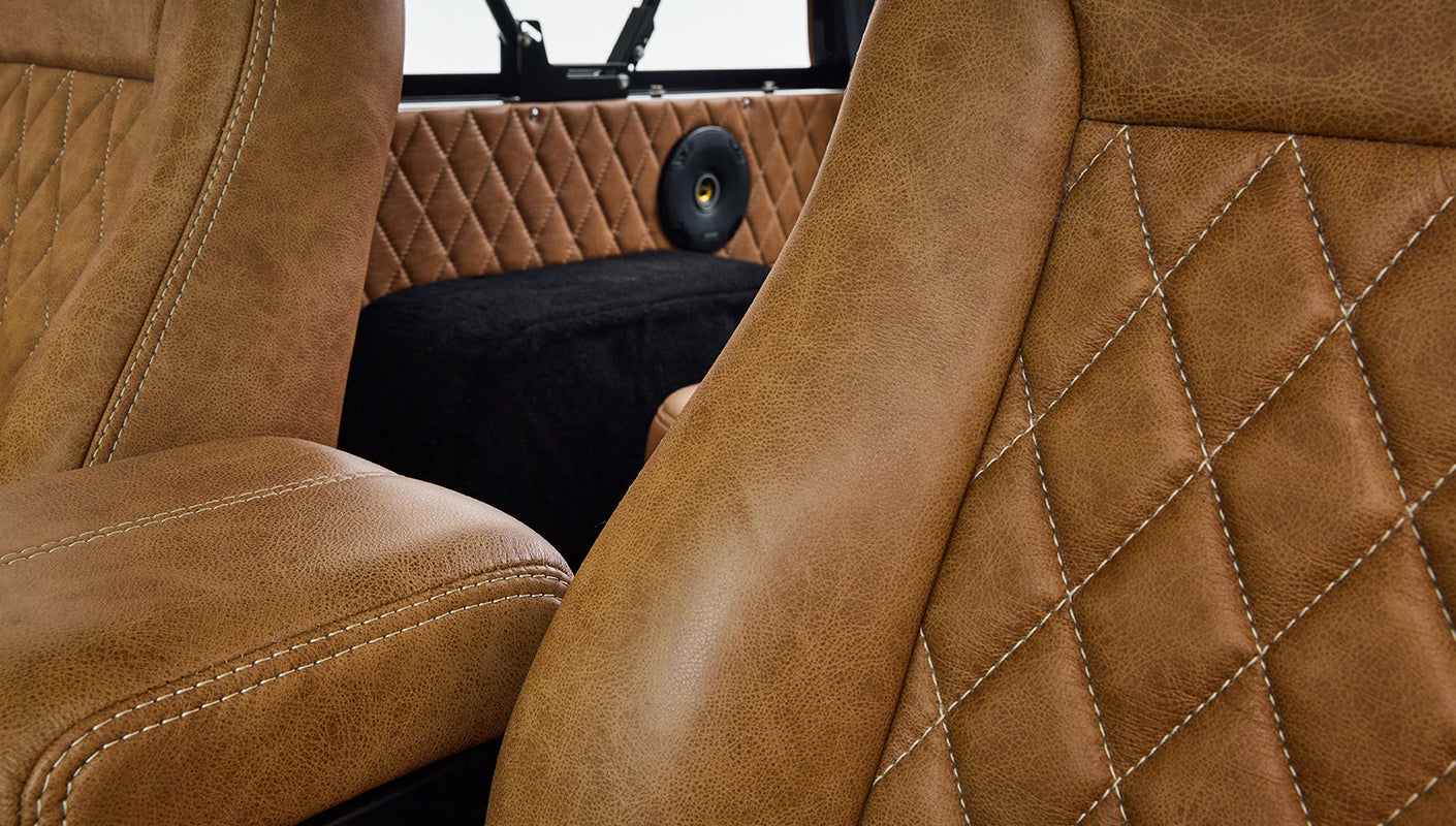 Close-up view of tan leather seats with stitching inside Classic Ford Bronco interior