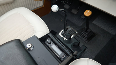 Interior floor area showing manual shifters and a radio with cup holders in Classic Ford Bronco