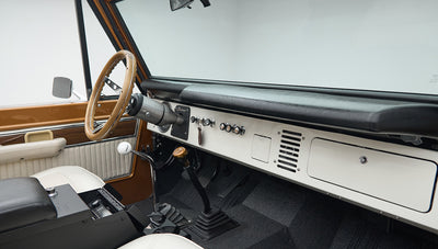 Classic Ford Bronco dashboard and center console with gear shifters and black armrest