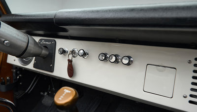 Classic Ford Bronco dashboard with knobs, ignition with key, and gear shifters