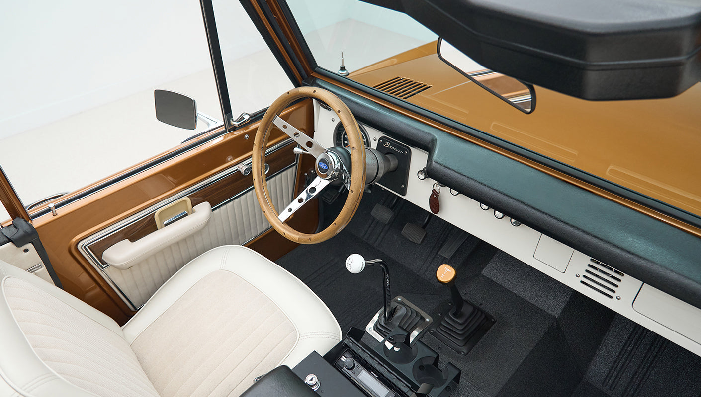 Wide view of Classic Ford Bronco interior showing dashboard, seats, and roll cage