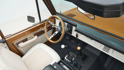 Wide view of Classic Ford Bronco interior showing dashboard, seats, and roll cage
