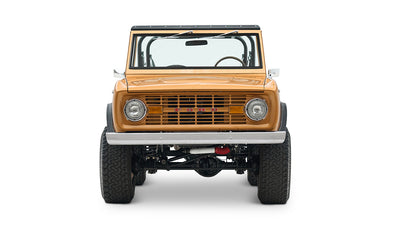 Front view of saddle bronze Classic Ford Bronco with round headlights and black wheel arches on white background