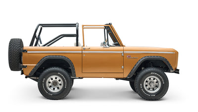 Side profile of Classic Ford Bronco in saddle bronze with black wheel arches and open roof on white background