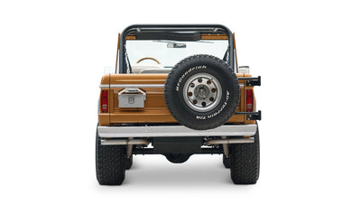 Rear view of Classic Ford Bronco in saddle bronze with spare tire on tailgate and red tail lights on white background