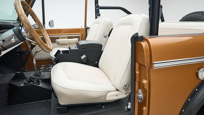 Interior front seats of Classic Ford Bronco with white upholstery and Saddle Bronze door