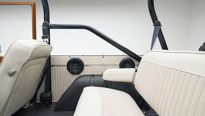 Close-up of rear seat area with black speakers and white upholstery inside Classic Ford Bronco