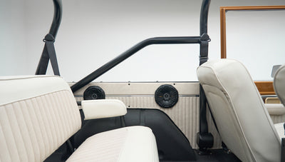 Interior view showing white vinyl seats and black roll cage bars of Classic Ford Bronco