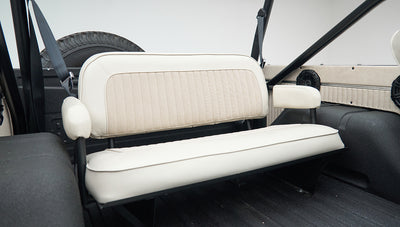 White bench seat and side armrests inside rear cabin of Classic Ford Bronco with black roll bar