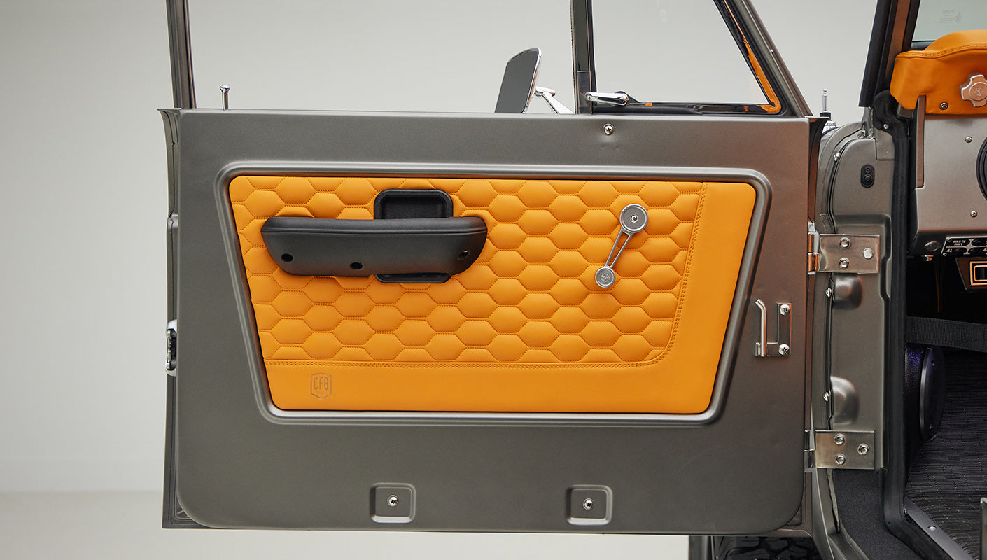 1972 classic ford bronco in matte silver with orange leather interior door panel