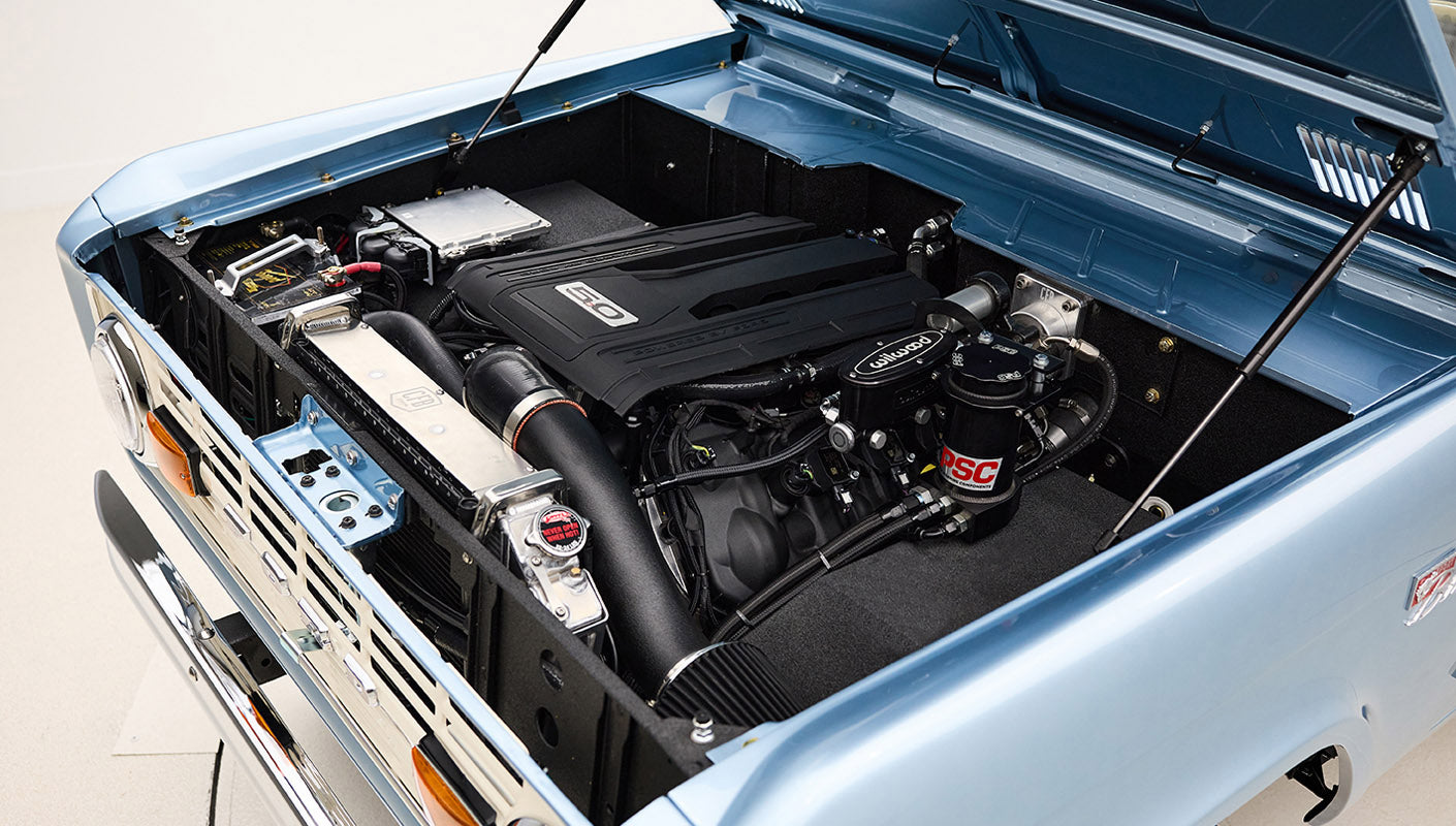 Front view Classic Ford Bronco 1974 Blue Coyote Series with open hood showing engine