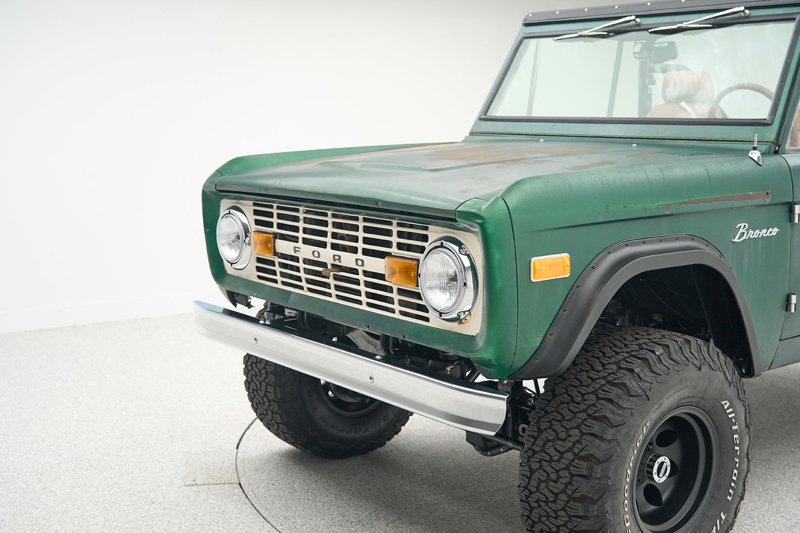 Classic Ford Bronco green with rear view showing tailgate and license plate on white background