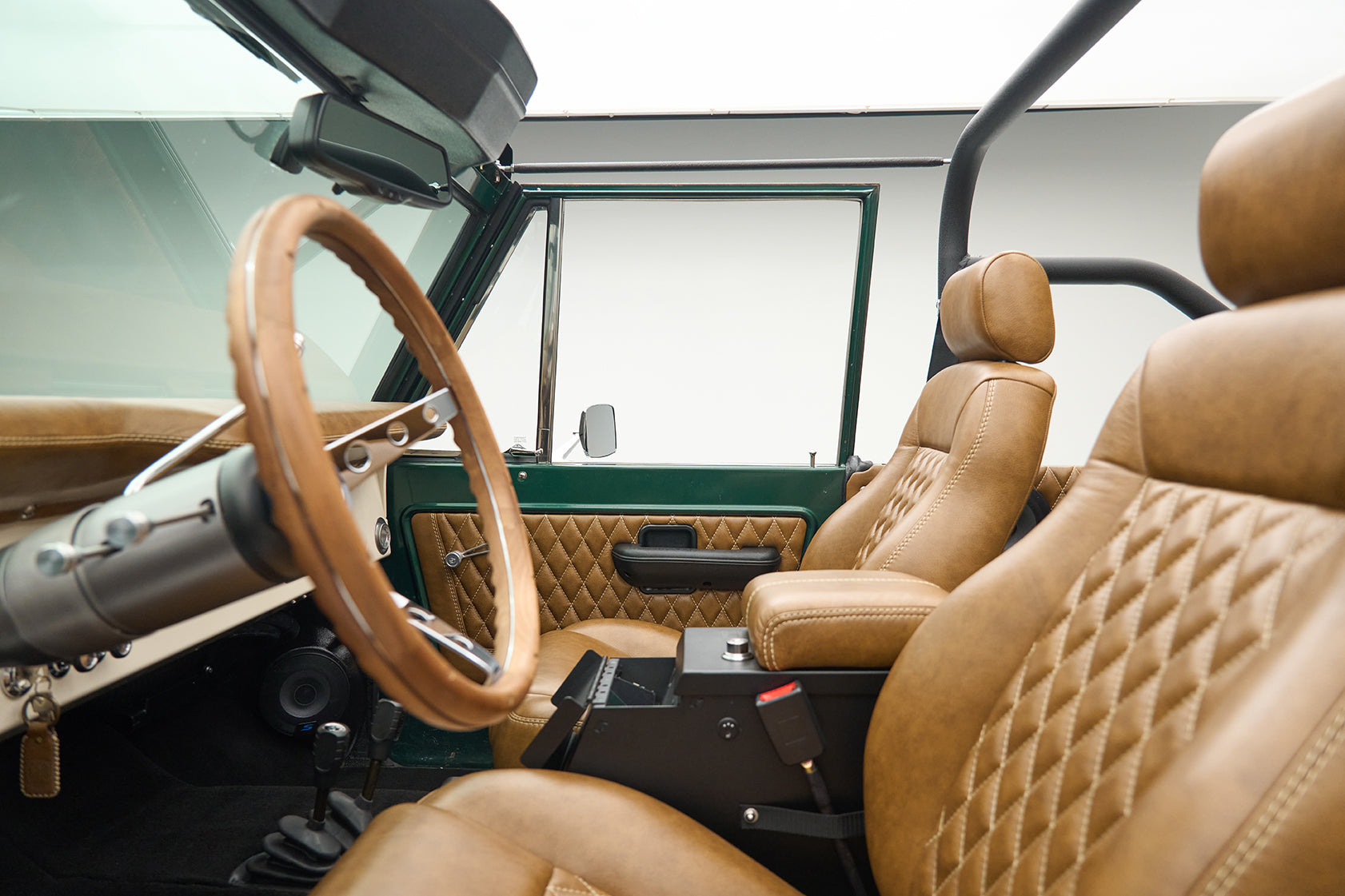 Interior view of Classic Ford Bronco showing tan bucket seats and steering wheel