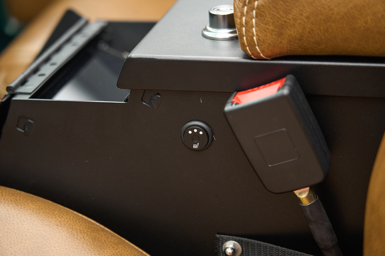 Close-up of heated seat control button on black metal panel inside vehicle