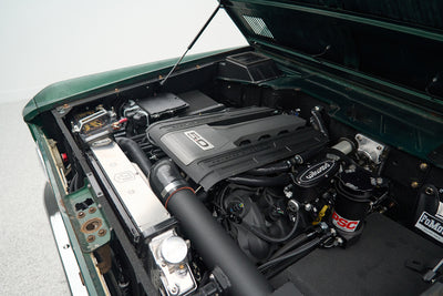 Engine bay of a Classic Ford Bronco showing a modern 5.0 Powerstroke engine with Wilwood brake components.