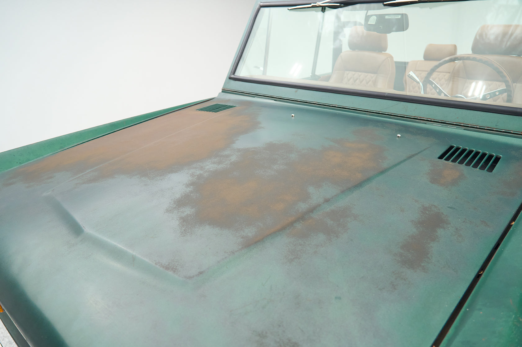 Close-up of green Ford Bronco hood with patina and visible wear