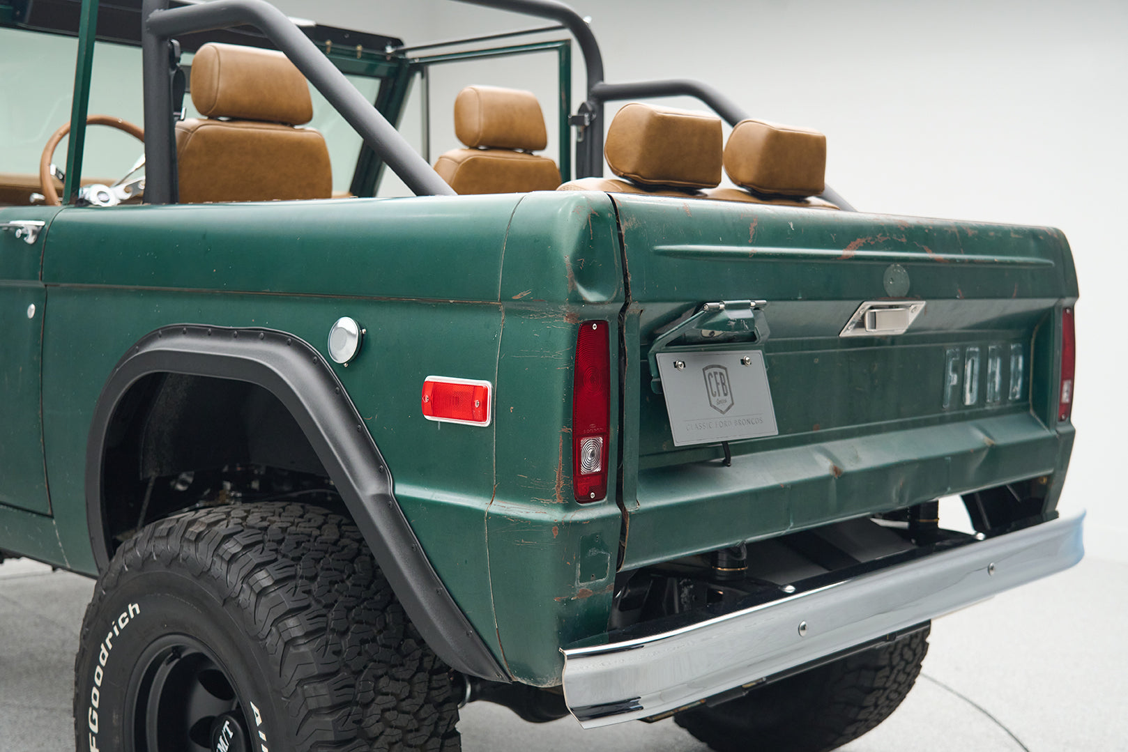 Green Ford Bronco rear quarter with spare tire and rugged tires