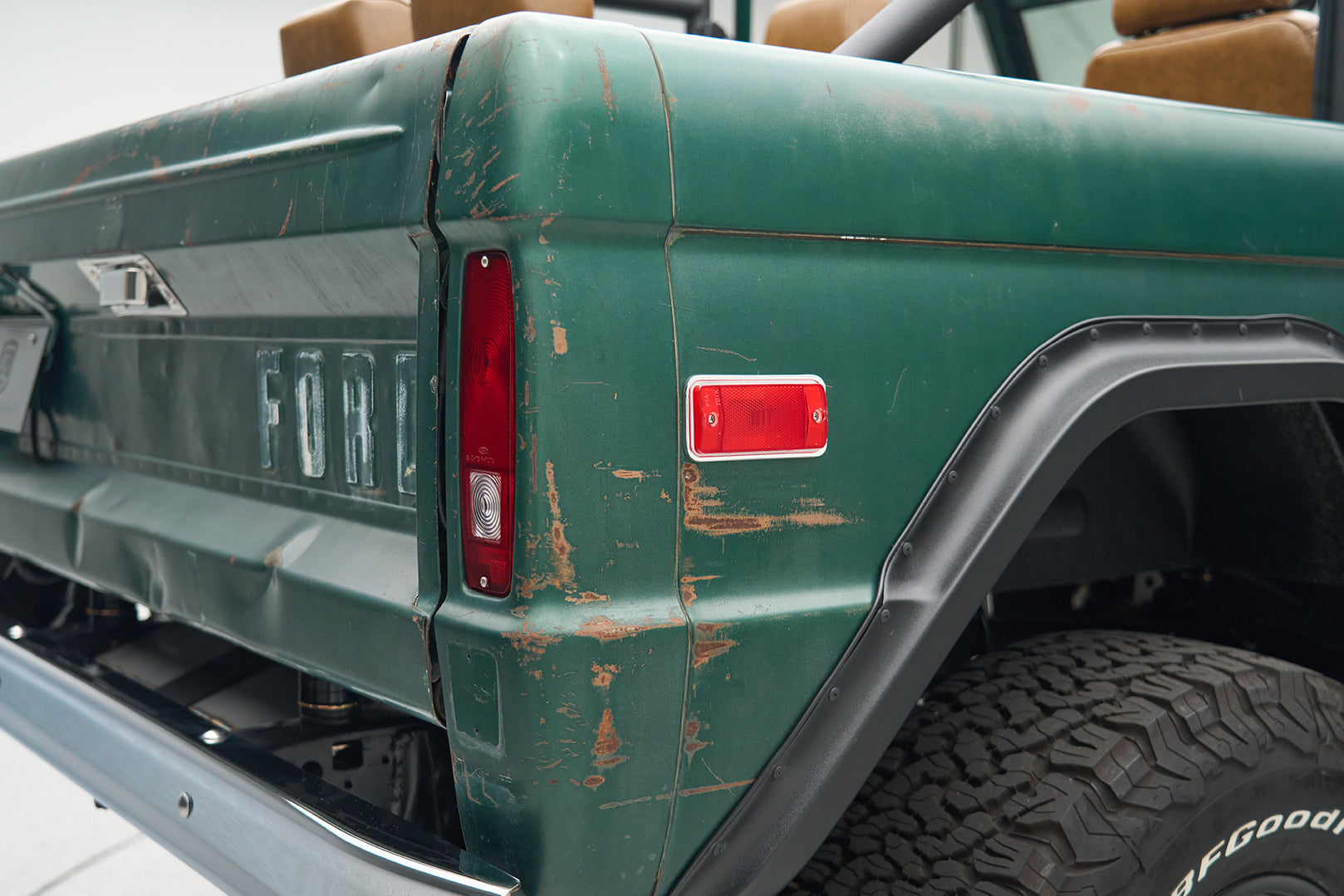 Rear side of green Ford Bronco showing taillights and wheel arch