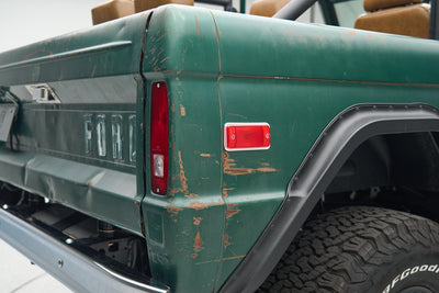 Rear side of green Ford Bronco showing taillights and wheel arch