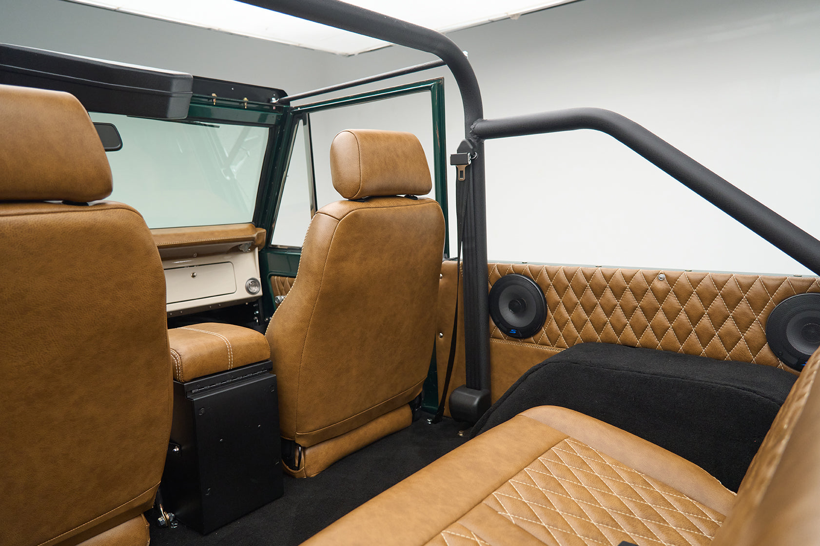 Interior view of Ford Bronco showing brown leather seats and rear speakers
