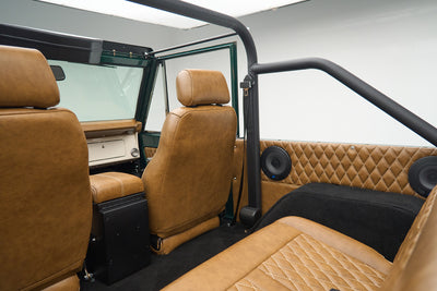 Interior view of Ford Bronco showing brown leather seats and rear speakers