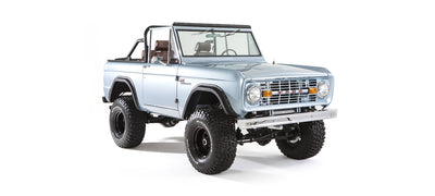 Three quarter front view of lifted light blue Classic Ford Bronco with open roof
