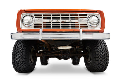 Front view of orange Classic Ford Bronco showing bumper, grille, and headlights.