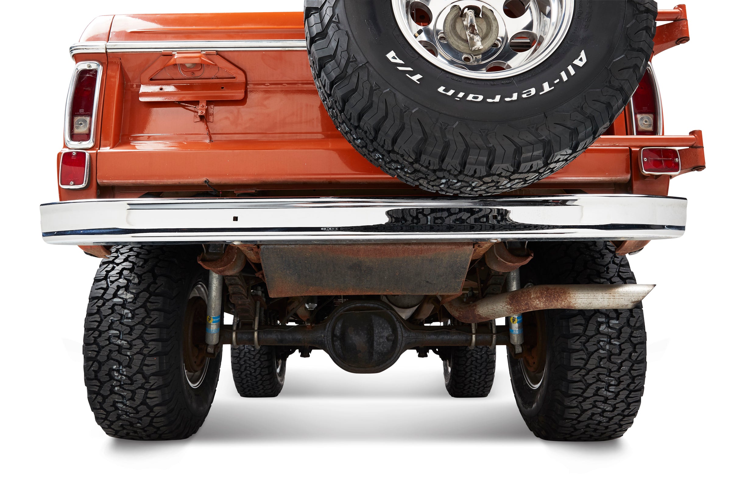 Rear view of a Classic Ford Bronco showing rear bumper, spare tire, and suspension components.