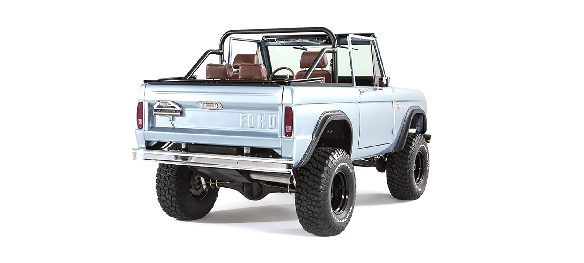 Rear three quarter view of light blue Classic Ford Bronco showing tailgate and tires